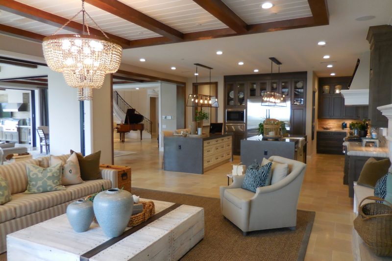 Spacious living room and open kitchen with elegant decor, chandelier, and comfortable furnishings.
