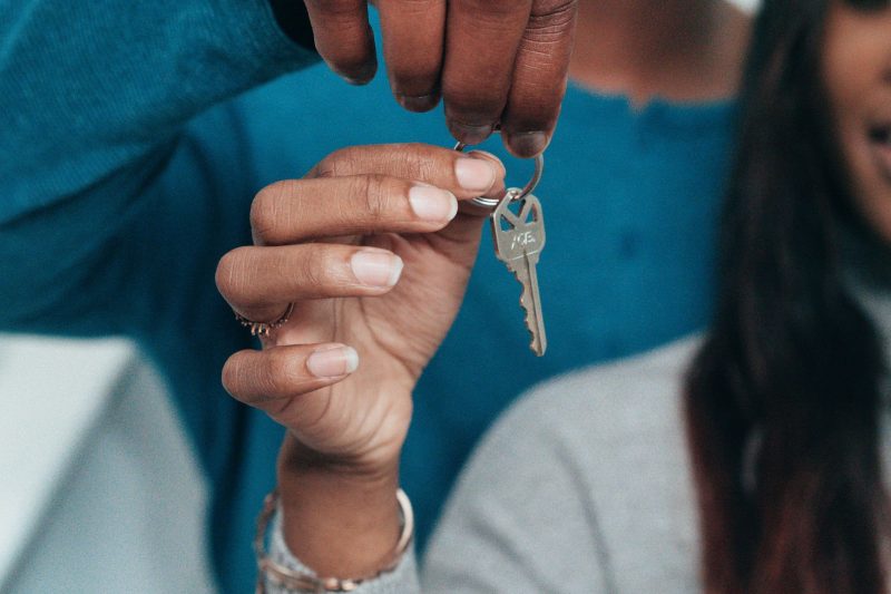 Home 29 A couple joyfully holding a house key, smiling, symbolizing new home ownership.
